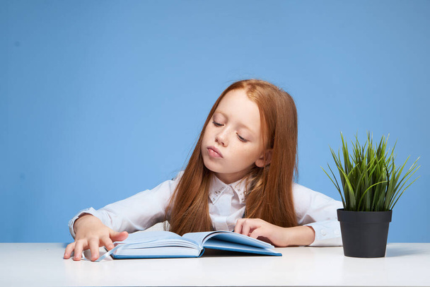 школьница, выполняющая домашнюю работу за столом - Фото, изображение