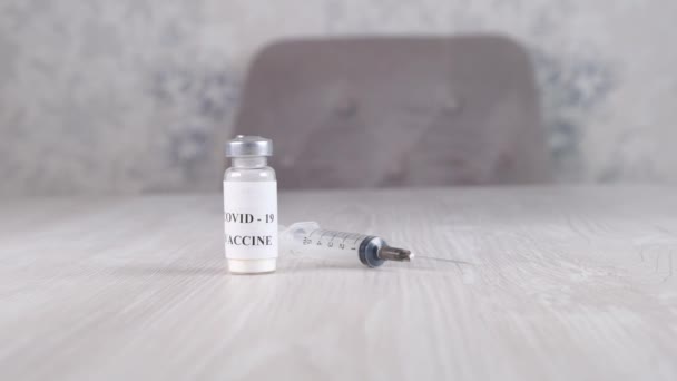 Vials with coronavirus vaccine and syringe on light background. Concept of corona virus treatment, injection, shot and clinical trial during pandemic - Footage, Video