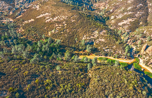 Vista aérea de formaciones rocosas en el Parque Nacional Pinnacles en California, restos arruinados de un volcán extinto en la falla de San Andrés. Hermosos paisajes, acogedoras rutas de senderismo para turistas y viajeros. - Foto, Imagen
