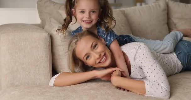 Mother spend time play with daughter while lying on couch - Záběry, video