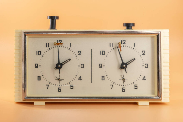 Шахматные часы изолированы на оранжевом фоне, время бежит у - Фото, изображение