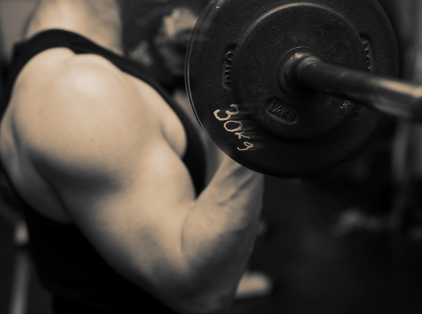 bodybuilding προπόνηση στο γυμναστήριο. αρσενικό ελεύθερα βάρη ανύψωσης. κατάρτισης με barbell για την οικοδόμηση των μυών και του δικέφαλου - Φωτογραφία, εικόνα