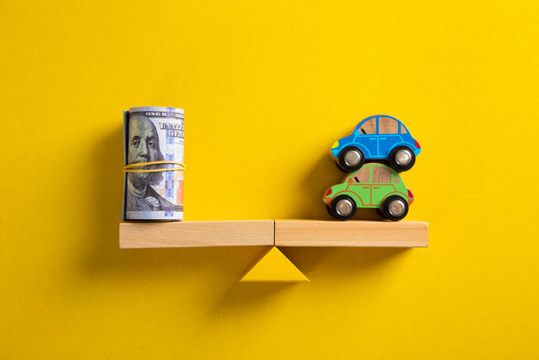 Car / Auto loan or transforming assets into cash concept : Car model, US dollar notes in jute bags on simple balance scale, depicts car owner or borrower turns personal properties into cash or wealth. - Photo, Image