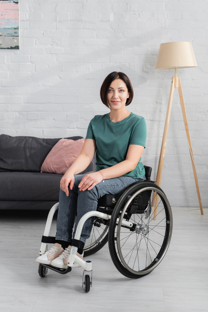 Behinderte Frau im Rollstuhl lächelt in Kamera  - Foto, Bild