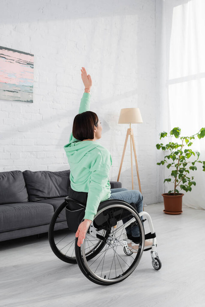 Morena disgustado mujer entrenamiento en silla de ruedas en casa  - Foto, imagen