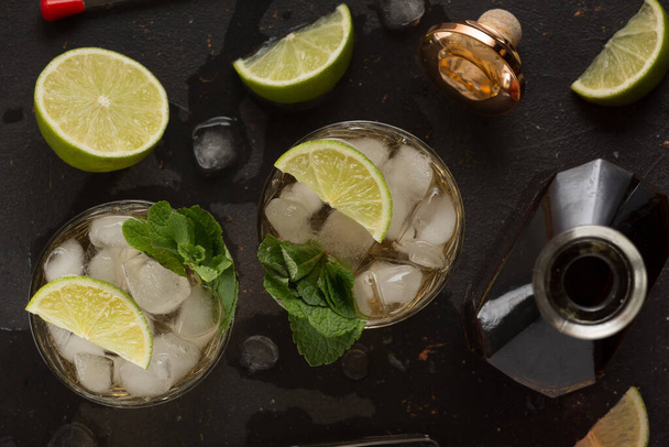 Alcoholic cocktail with rum and ice and mint on a dark background in a bar - Photo, Image