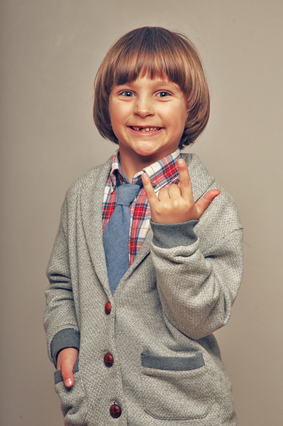 jongen toont heavy metal gebaar - Foto, afbeelding