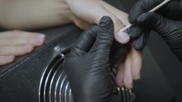 gedeeltelijk zicht van de manicure met orangewood stick op de vinger van de cliënt - Video