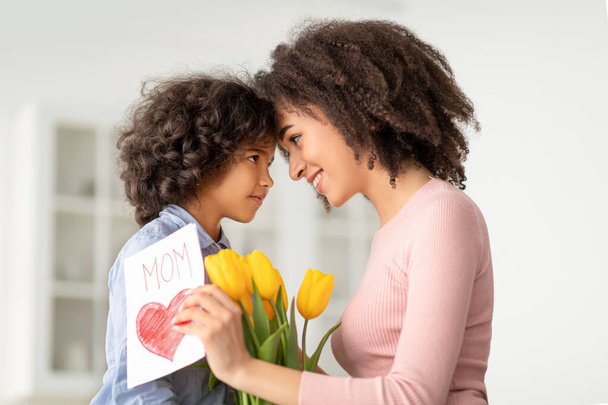 Fekete lány köszönti anya tulipán és kártya - Fotó, kép