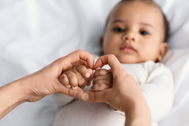 Close-up van schattige kleine Afrikaanse Amerikaanse babys handen - Foto, afbeelding