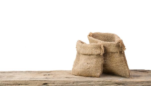 Two different size burlap bags on grunge wooden  shelf with copy space isolated over white background - Photo, Image