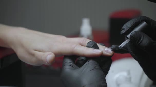 vista recortada de esteticista aplicando esmalte de uñas en el dedo de la mujer - Imágenes, Vídeo