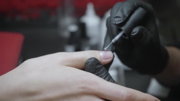 částečný pohled na manikúru nanášející lak na nehty na prst ženy - Záběry, video