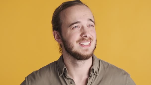 Ritratto di giovane uomo barbuto che ondeggia nessun gesto in disaccordo con la tua opinione su sfondo giallo - Filmati, video