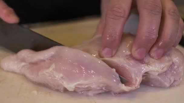 Close Up Of Female Hands Slicing Raw Chicken Meat With Knife On Chopping Board. Locked Off - Footage, Video