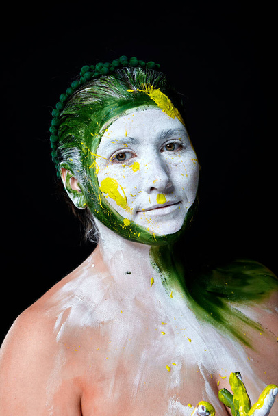 Πορτραίτο μιας γυναίκας με ζωγραφισμένο πρόσωπο. Δημιουργικό μακιγιάζ και φωτεινό στυλ.Κορίτσι με χρωματιστό πρόσωπο βαμμένο. Art beauty image.girl με πολύχρωμο χρώμα στο πρόσωπό της.  - Φωτογραφία, εικόνα
