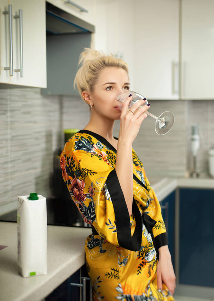Nuori liitutaulu keittiössä pakkaus terveellistä luonnollista mehua juomia lasista - Valokuva, kuva