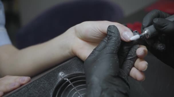 vista parziale di estetista in guanti di lattice lucidatura unghie del cliente - Filmati, video