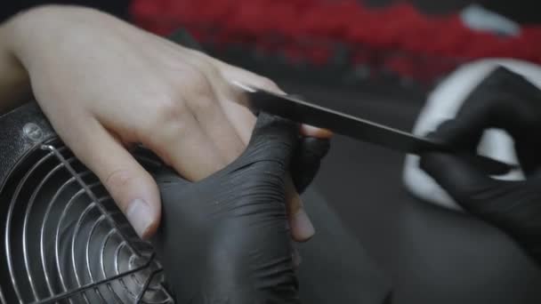 częściowy widok kosmetyczki w lateksowych rękawiczkach wypełniających paznokcie klienta - Materiał filmowy, wideo
