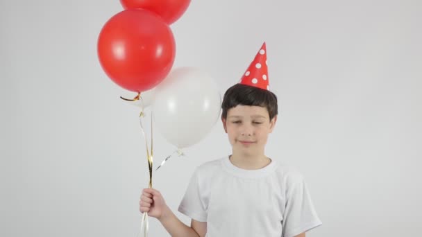 Verjaardag. Verjaardagsfeest met ballonnen. Gelukkige jeugd. Leuke jongen met een verjaardagshoed. 4K - Video