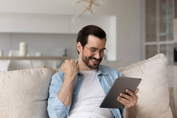Happy man use tablet win online lottery - Фото, зображення
