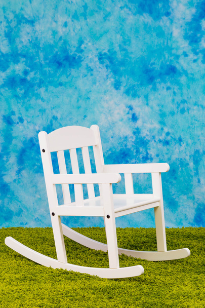 White child s chair on sky and grass backround - 写真・画像