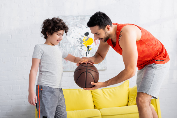 Usmívající se arabský muž s basketbalovým učitelem syna doma  - Fotografie, Obrázek