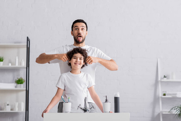 Arabo padre attaccare fuori lingua vicino figlio in bagno  - Foto, immagini
