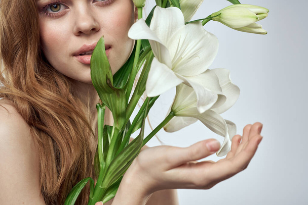 Femme émotionnelle avec des fleurs modèle printemps épaules nues peau claire - Photo, image