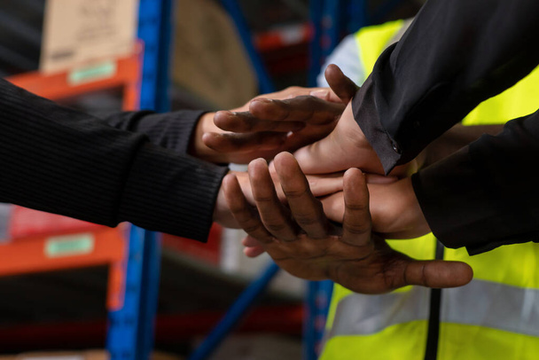 Εργάτες στοιβάζοντας τα χέρια μαζί σε αποθήκη ή αποθήκη - Φωτογραφία, εικόνα