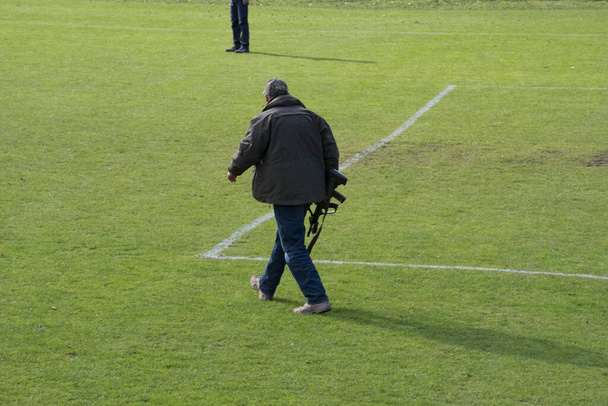 francotirador con un rifle en la mano caminando sobre un prado verde - Foto, imagen