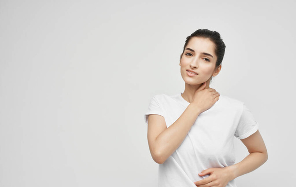 vrouw in wit t-shirt gezondheidsproblemen lichaam pijn ongemak - Foto, afbeelding
