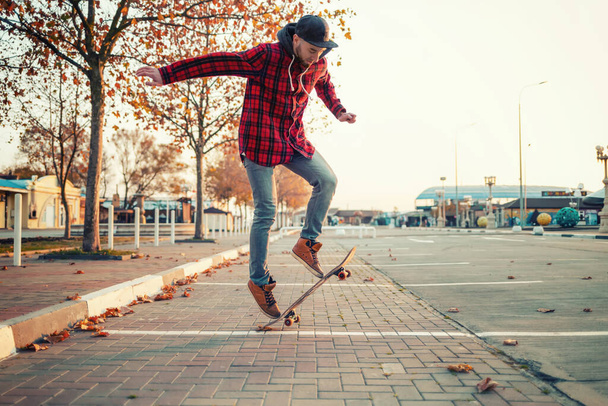 Skateboarding. Un hombre hace un truco de Ollie en una patineta. Saltar en el aire. - Foto, imagen