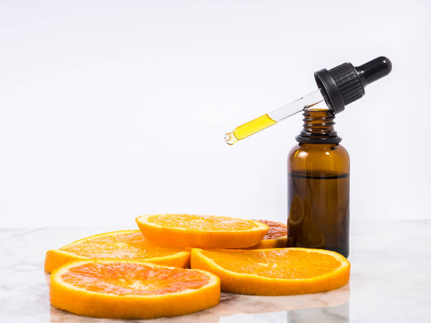Vitamin C serum bottle with dropper on white marble background - Photo, Image