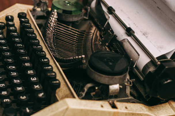 macchina da scrivere vintage con chiavi su fondo di legno e foglio bianco - Foto, immagini