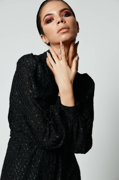 aantrekkelijke vrouw met heldere make-up handen in de buurt van luxe model gezicht - Foto, afbeelding