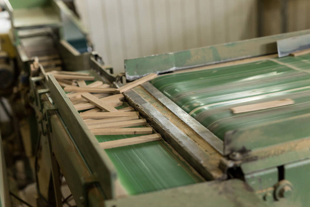 Το κοντινό πλάνο των διακοσμητικών μη πελεκημένων ξύλινων μπλοκ σε πράσινη τέμνουσα μηχανή - Φωτογραφία, εικόνα