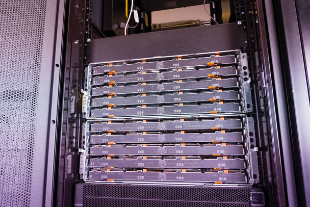 крупный план сервера с лотками, заполненными жесткими дисками внутри облачного центра Интернета - Фото, изображение