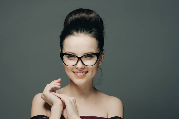 pretty brunette with glasses naked shoulders attractive look dark background - Photo, Image