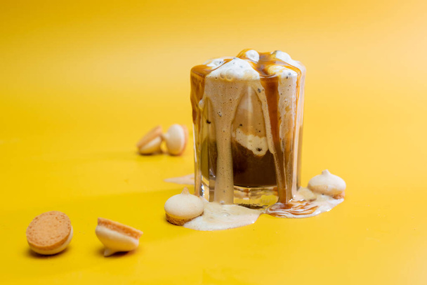 καφέ ποτό με λεπτή μαρμελάδα και ροή αφρού σε κίτρινο φόντο - Φωτογραφία, εικόνα