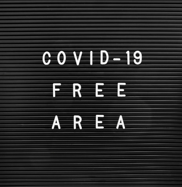 COVID-19フリーエリア。メッセージのための変更可能なレターボード、ホワイトプラスチック文字. - 写真・画像