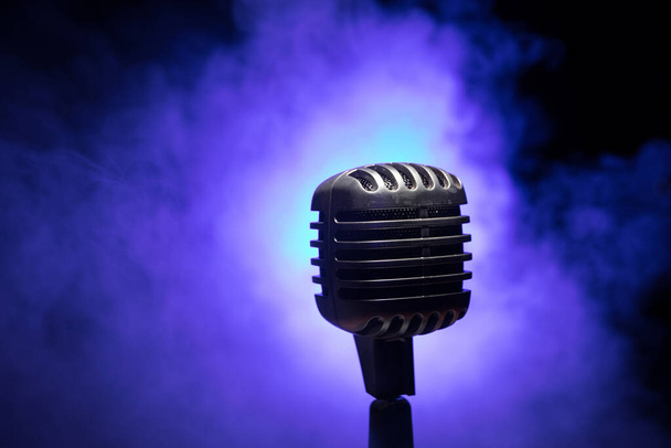 Mikrofon im Retro-Stil auf Hintergrund mit Hintergrundbeleuchtung. Vintage Silber Mikrofon für Sound, Musik, Karaoke. Sprachübertragungsgeräte. Live-Pop, Rock-Musik. Selektiver Fokus - Foto, Bild