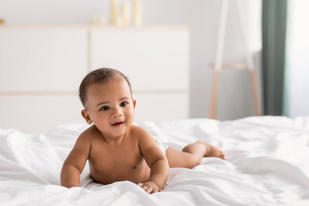 Carino piccolo bambino afroamericano sdraiato sul letto - Foto, immagini