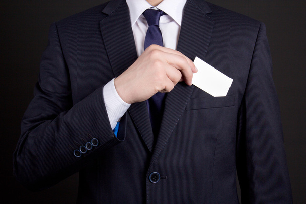 businessman holding visiting card out of his suit pocket - Fotó, kép