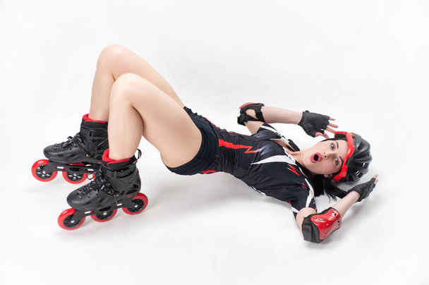 slim woman in sportswear and helmet in roller skates on white background - Foto, immagini