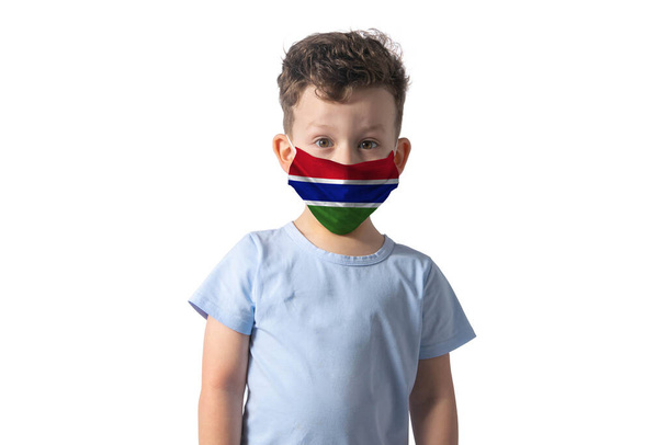 Αναπνευστήρας με σημαία Γκάμπια. Λευκό αγόρι βάζει ιατρική μάσκα προσώπου απομονώνονται σε λευκό φόντο. - Φωτογραφία, εικόνα