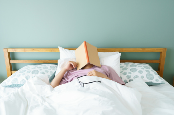 Aziatische knappe man Lees boeken tijdens het slapen. Man boek omslag Slaperigheid veroorzaakt slaap. Het concept van voldoende slaap. Slaap lekker. - Foto, afbeelding