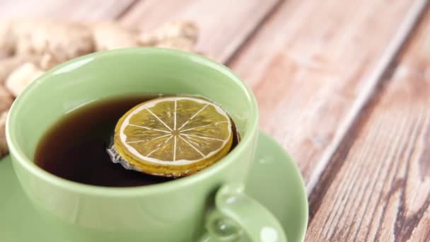 tè allo zenzero con limone su sfondo di legno. - Filmati, video