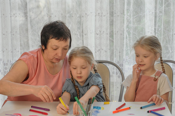 grand-mère dessine avec les petites-filles à la maison - Photo, image