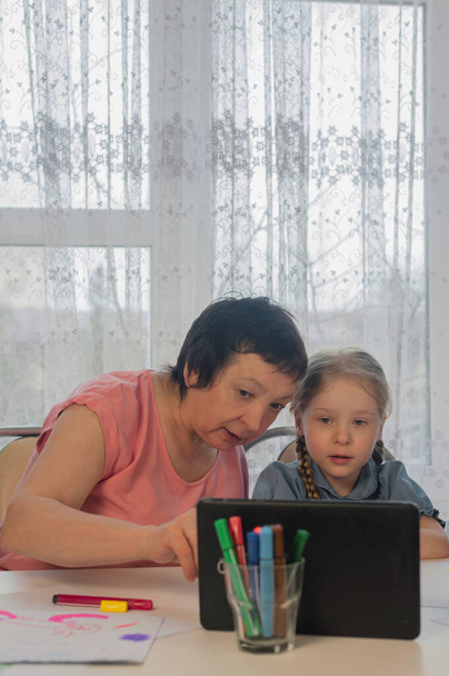 babcia pokazuje dwie wnuczki rysunek lekcji na tablecie w domu - Zdjęcie, obraz